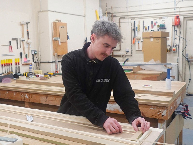 Photograph of a drawing board and someone drawing a plan of a kitchen.