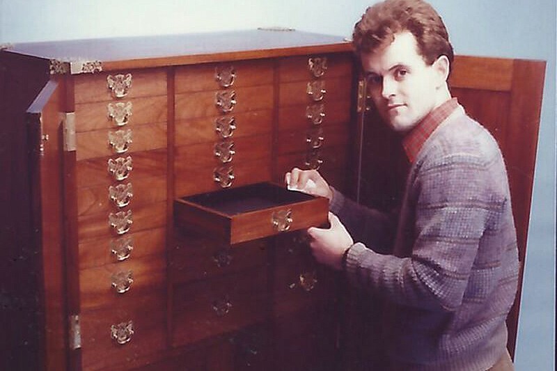 A photograph of David Lisle in the mid 1980s with a piece of bespoke furniture.